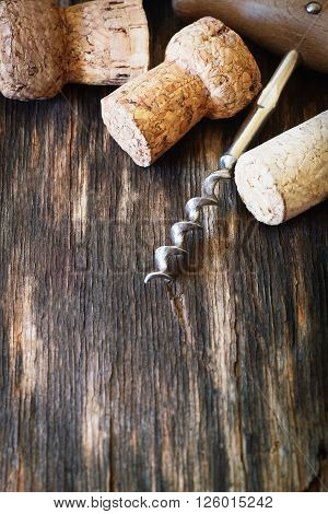Old corkscrew for wine and wine corks on a vintage wooden background. Close-up. Toned image. Selective focus. Copy space background
** Note: Shallow depth of field