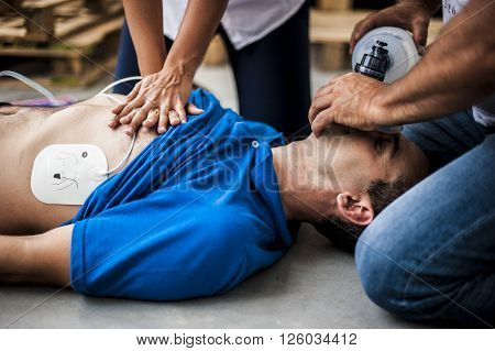 rescuers assisting an unconscious man with cardiac resuscitation and ventilation