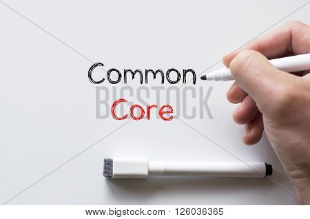 Human hand writing common core on whiteboard