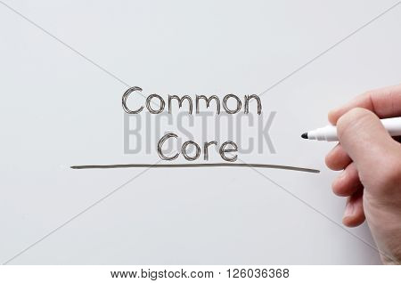 Human hand writing common core on whiteboard