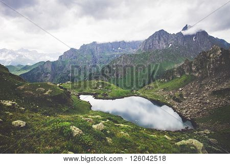 Landscape of Lake and Rocky Mountains with sky clouds Summer Travel serene aerial view moody weather
