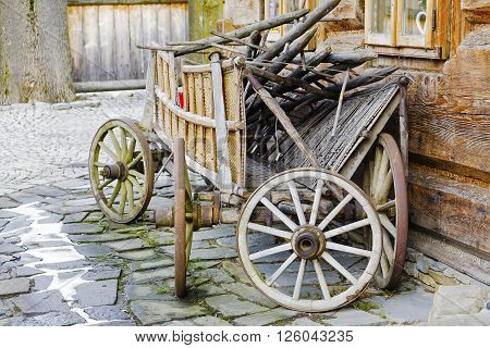 ZAKOPANE POLAND - MARCH 09 2016 Wooden waggon set against the wall of the building constructed in the traditional way with wooden logs. This scene reminds tradition of the region
** Note: Visible grain at 100%, best at smaller sizes