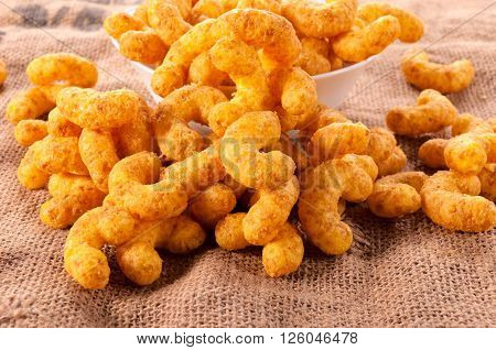 Peanut puffs splashed on the table on rustic background
