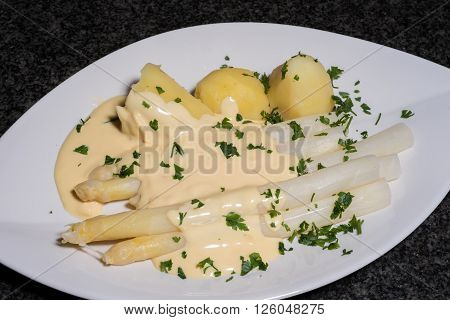 cooked white asparagus with potatoes and parslay