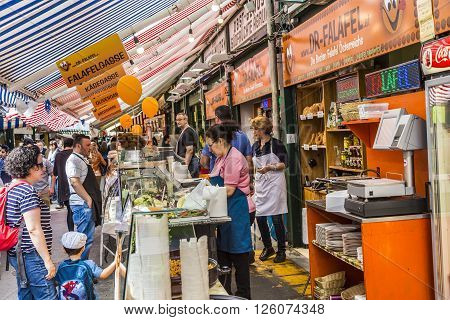 VIENNA AUSTRIA - APR 28 2015: people enjoy the Naschmarket in Vienna. Since the 16th century people in Austria has come to the Naschmarkt get to enjoy the many different products from local producer.