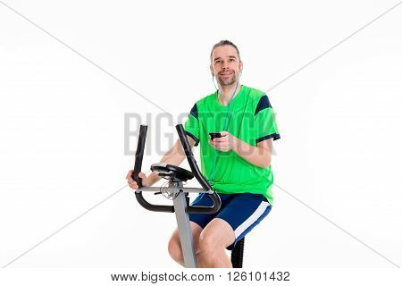 young man in green shirt train with fitness machine and listening music