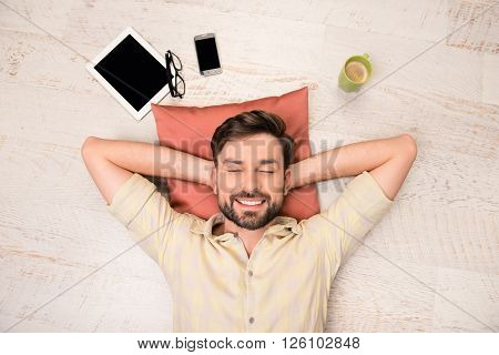 Portrait Of Happy Man Lying On Floor And Dreaming About Smth