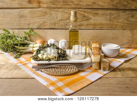 Is tucked with eggs shoots of edible spring grass with sheep cheese