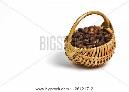 Bast basket with pine nuts on a completely white background.