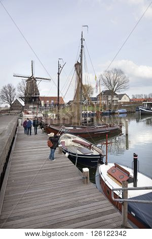 harderwijk, netherlands, 1 april 2016: old harbor in dutch town of harderwijk with windmill De Hoop in the background