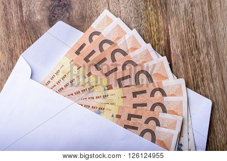 envelope full of money euro on wood for concept