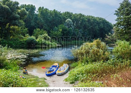 Active boy resting after adventurous experience kayaking on the river on a sunny day during summer vacation