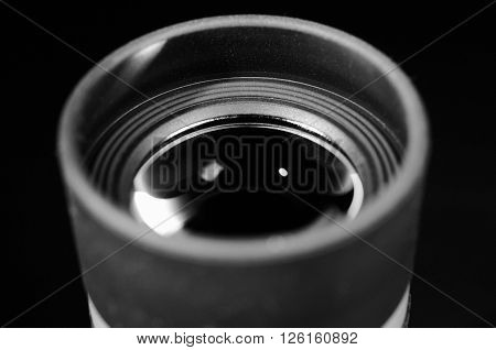 Lens of eyepiece with rubber eyecup. Selective focus. Macro. Close up view. Vintage photo. Black and white.