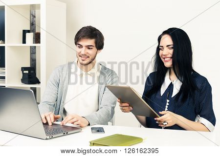 Man and woomen working together. Top view of two young people working together while sitting in minimalistic athmosphere