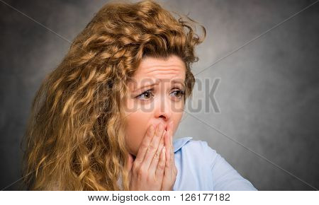     Scared young woman with her hand on her mouth 