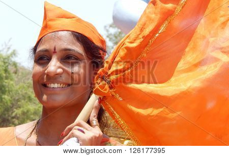 HYDERABAD,INDIA-APRIL 15:Portrait of an Indian Hindu woman waving saffron flag a tradition during sri ram navami festival celebrations on April 15,2016