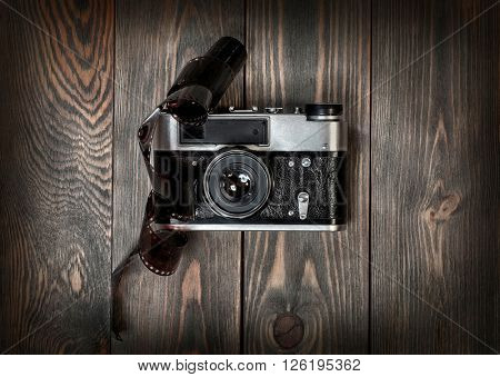 Retro film photo camera on the wooden background.