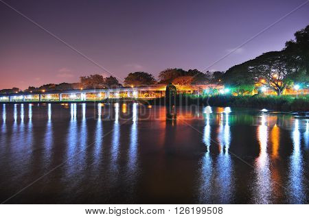 Lower Seletar Reservoir (in the north of Singapore) with light reflections from park connector under reddish and purplish night sky
