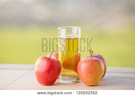 apples and apple juice on a wooden table, outdoor
