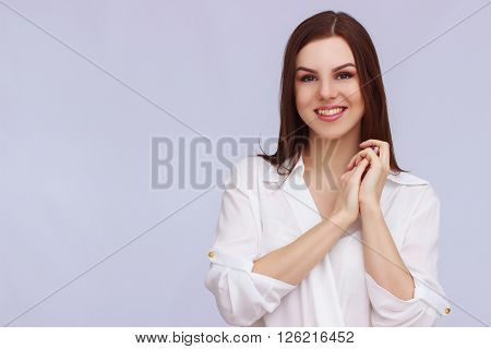 Portrait of hopreful business woman on grey background