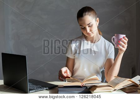 girl with a mug is preparing for the exam reading the Carnet