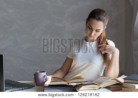 girl with a mug is preparing for the exam reading the Carnet