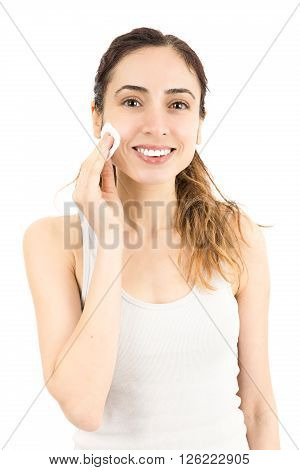 Attractive cauasian woman cleaning her make up with cotton ball. Isolated on white background.