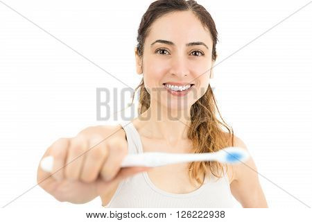 Smiling attractive caucasian woman showing her toothbrush. Isolated on white background.