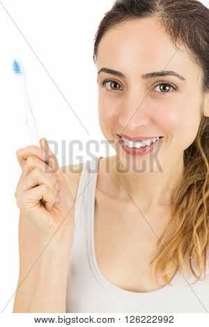 Smiling woman holding up her toothbrush. Isolated on white background.