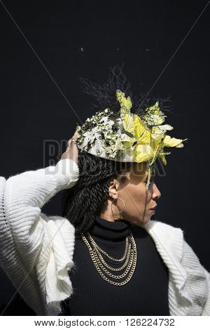 NEW YORK - MAR 27 2016: A woman wearing an Easter bonnet of yellow flowers and butterflies walks along 5th Ave on Easter Sunday for the traditional Easter Bonnet Parade in Manhattan on March 27, 2016.
