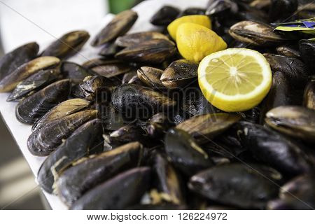 Turkish style stuffed mussels called midye dolma on the bench for sale with a piece of lemon