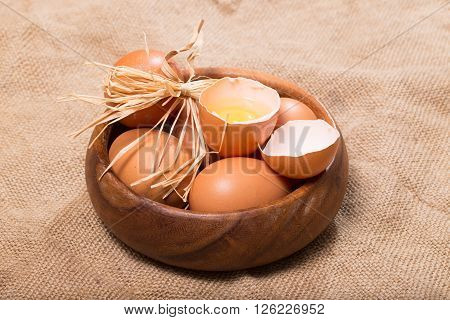 Eggs on a sacking. One egg is broken rural style a close up