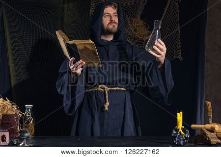 Portrait of a crazy medieval scientist working in his laboratory. Alchemist. Halloween.