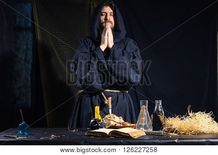 Portrait of a crazy medieval scientist working in his laboratory. Alchemist. Halloween.