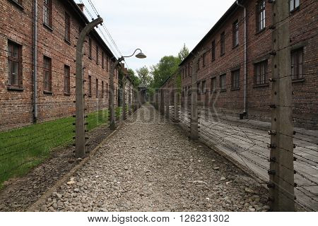 Oswiecim, Poland - May 09, 2015: Electric Fence And Buildings In Former Nazi Concentration Camp Ausc