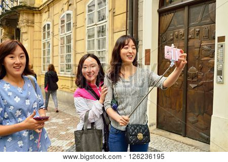 PRAGUE, CZECH REPUBLIC - AUGUST 18, 2015: woman taking selfie. A selfie is a self-portrait photograph, typically taken with a camera phone held in the hand or supported by a selfie stick.