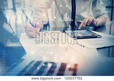 Photo working process. Account manager working new global project in office. Using tablet. Graphics icons, worldwide stock exchanges interface.