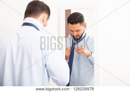 Tying Knot On A Necktie In Front Of Mirror