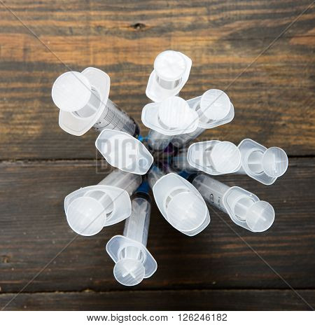 Group of syringes on the wooden bavkground