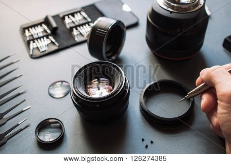 Precision optical dslr lens service, adjustment and alignment. Camera lens repair set in photo engineer workshop. Maintenance support of photographic 50 1.4 photo camera lens.
