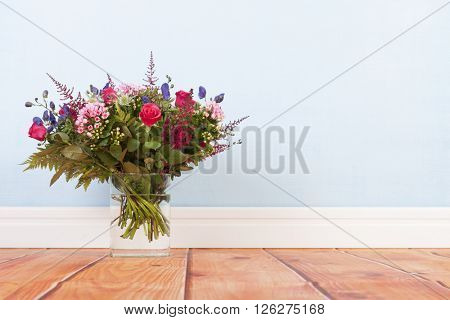 mixed bouquet flowers on floor on blue background