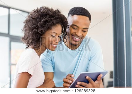 Happy couple using digital tablet at home