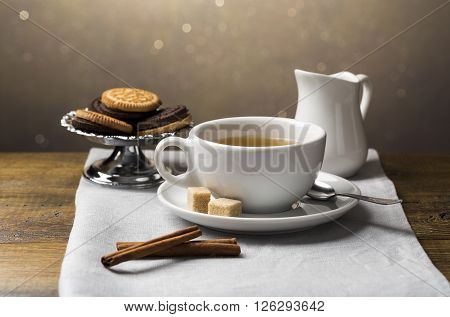 A set of tea cups with saucer and milk jug on light grey napkin