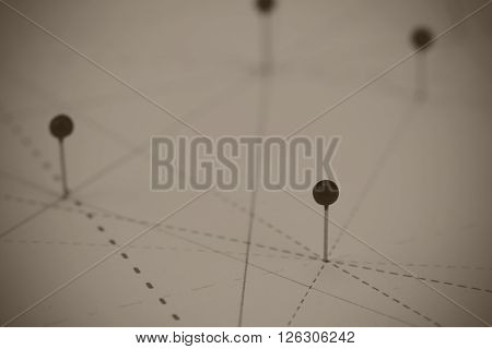 Black Pins In Paper Linked By Lines