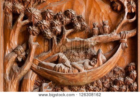CHIANG MAI, THAILAND - FEB 21: Silhouette of a man sleeping in a hammock carved ancient wall inside Wat Buppharam temple on February 21, 2016. The temple was established in 1497 by King Muang Kaew