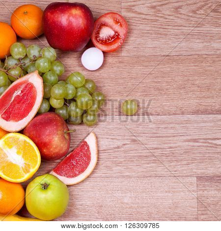 Many juicy whole and cut fruit on a wooden table