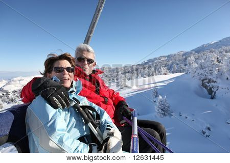 Üst düzey bir adam ve bir chairlift oturan üst düzey kadın