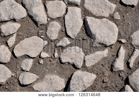 The texture of the stones and wet earth. Stones in the drying puddle