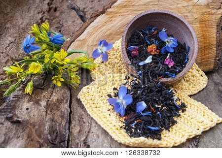 Tea in a wooden bowl on the background of the spring flowers.