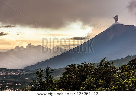 Sunset over active smoking Fuego volcano near Spanish colonial town & UNESCO World Heritage Site of Antigua, Guatemala, Central America